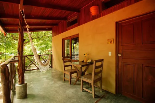front view of a house with wooden tea table and hammock