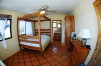 beautifully decoragted room with queen size bed, fan and reading table