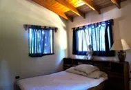 beatifully decorated room with two large windows and a queen size bed