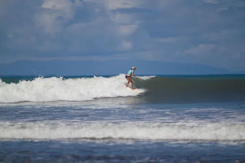 woman enjoying surfing in crystal clear water
