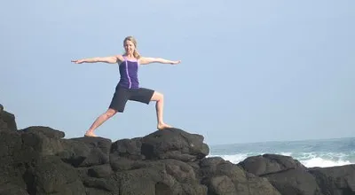 woman practicing yoga at the beach