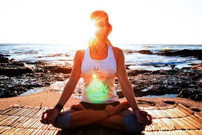 woman meditating on the beach