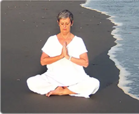 woman meditating besides sea beach